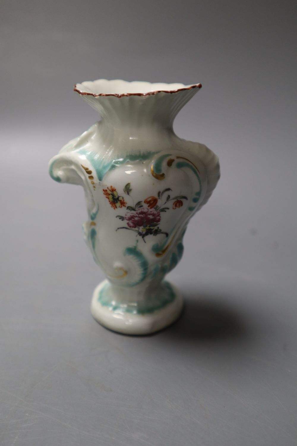 A Derby asymmetric vase moulded with rococo scrolls and painted with flower and a Derby plate painted with flower,